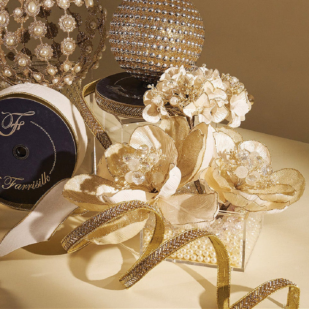 Farrisilk luxury ribbons in gold and crystal finishes styled with pearl ornaments and floral accents, showcasing a curated collection of bold and elegant design.