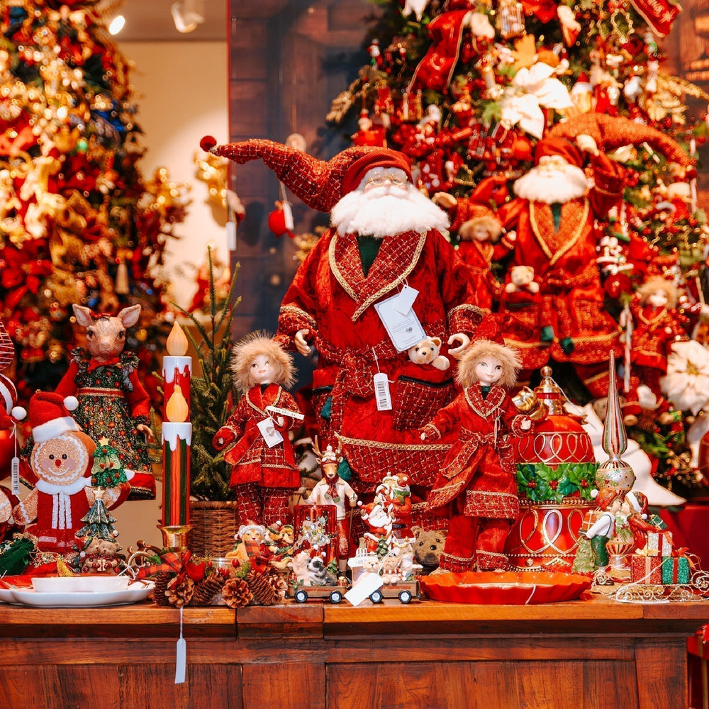 Elegant Christmas display with Santa figurines, elves, and festive tree decorations.