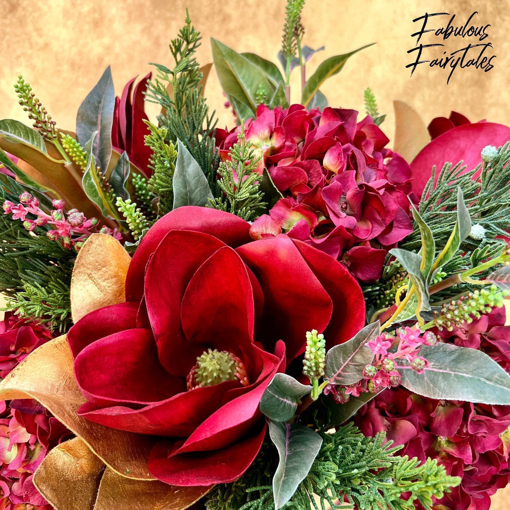 Winward Silks luxury Christmas floral bouquet with red magnolia, hydrangea, greenery, and gold background.