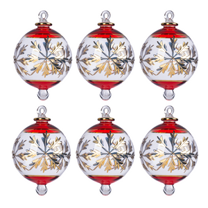 Hand-blown clear glass Christmas ornament with red rim and gold snowflake design.