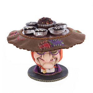 Katherine’s Collection witch cake plate holding treats on her hat